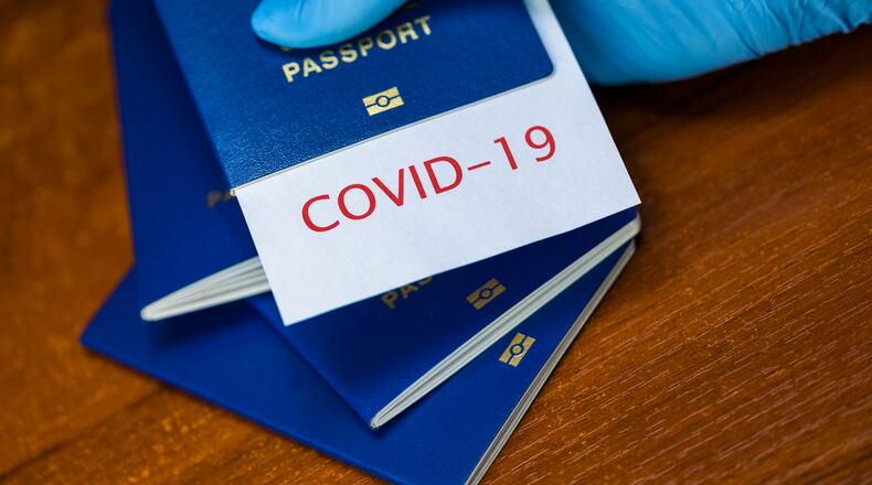 Man holding a passport with COVID-19 sign stamped onto a white paper. SITA has launched HealthProtect for airlines to share health information. Source: SITA