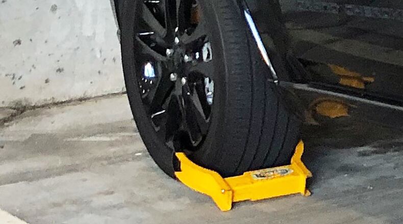 A vehicle booted in a private parking deck in Buckhead. A bill moving through the Georgia Legislature would make it all-but-illegal to use booting as a method of parking enforcement.