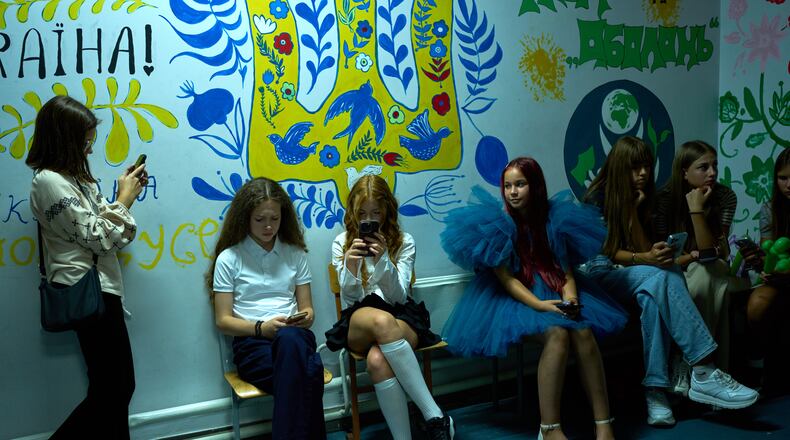 Young girls sit in an underground shelter during an air raid alarm during the traditional back to school celebrations in Kyiv, Tuesday, Sept. 1, 2026. (AP Photo/Francisco Seco)