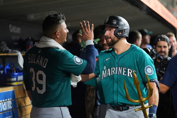 Seattle Mariners' Cal Raleigh right, celebrates his grand slam with Donovan Solano (39) against the Detroit Tigers in the ninth inning during a baseball game, Friday, July 11, 2025, in Detroit. (AP Photo/Paul Sancya)