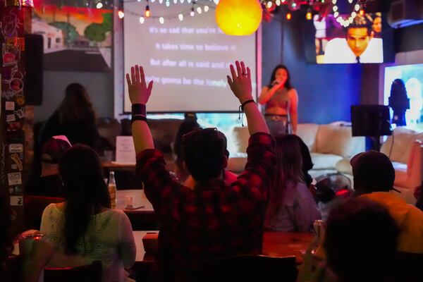 Members of Oye Fest sing and dance during a karaoke night at Estoria Bar in 2025.
(Olivia Bowdoin for the AJC)