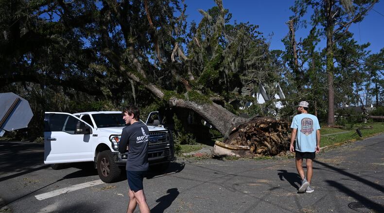 Austin Fosdick (left) and Nealy Hiers, both students at Valdosta State University, check out damages caused by Hurricane Helene near Valdosta State University, Saturday, September 28, 2024, in Valdosta. The devastation in Valdosta was extensive after the South Georgia city was battered with hurricane-force winds on Helene’s path across the state. Damaging Helene has swept through Georgia, leading to at least 15 deaths. All 159 counties are now assessing the devastation and working to rebuild, even as serious flooding risks linger. (Hyosub Shin / AJC)