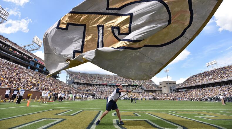 Georgia Tech cheerleader team member waves a giant Georgia Tech flag in the first half against the Tulane Green Wave at Bobby Dodd Stadium on Saturday, September 12, 2015. HYOSUB SHIN / HSHIN@AJC.COM