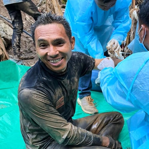 In this image released by Metta Tham Rescue Kalasin, rescuers, left, sit after rescuing people who have been trapped in a cave in Xaisomboun province, Laos. Wednesday, May 27, 2026. (Metta Tham Rescue Kalasin via AP)