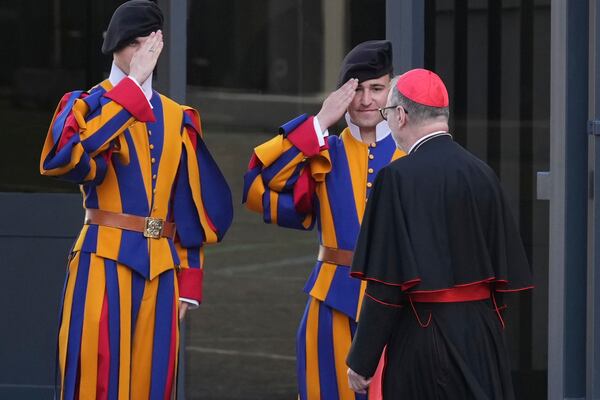 Vatican Swiss Guards salute a cardinal arriving for a meeting of cardinals, at the Vatican, Tuesday, April 22, 2025. (AP Photo/Andrew Medichini)