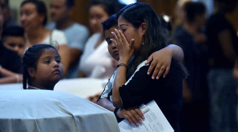 Lawrenceville - Family members mourn in front of the caskets of the victims — Martin Romero, 33, and four of his children — before the funeral mass for at St. Lawrence Catholic Church in Lawrenceville on July 13, 2017. Thirty-three-year-old Martin Romero and children Axel, 1, Dillan, 4, Dacota, 6 and Isabela Martinez, 10, were stabbed to death last week in their Loganville home. Nine-year-old daughter Diana Romero survived the attack. HYOSUB SHIN / HSHIN@AJC.COM