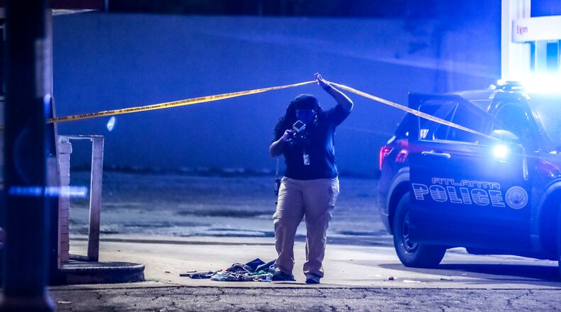 An Atlanta police crime scene technician investigates a shooting last month. (John Spink / John.Spink@ajc.com)