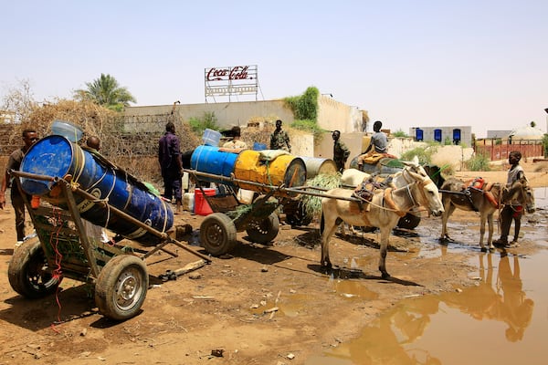 People fill water containers at a distribution point due to water outages in Khartoum, Sudan, Sunday, May 25, 2025. (AP Photo)
