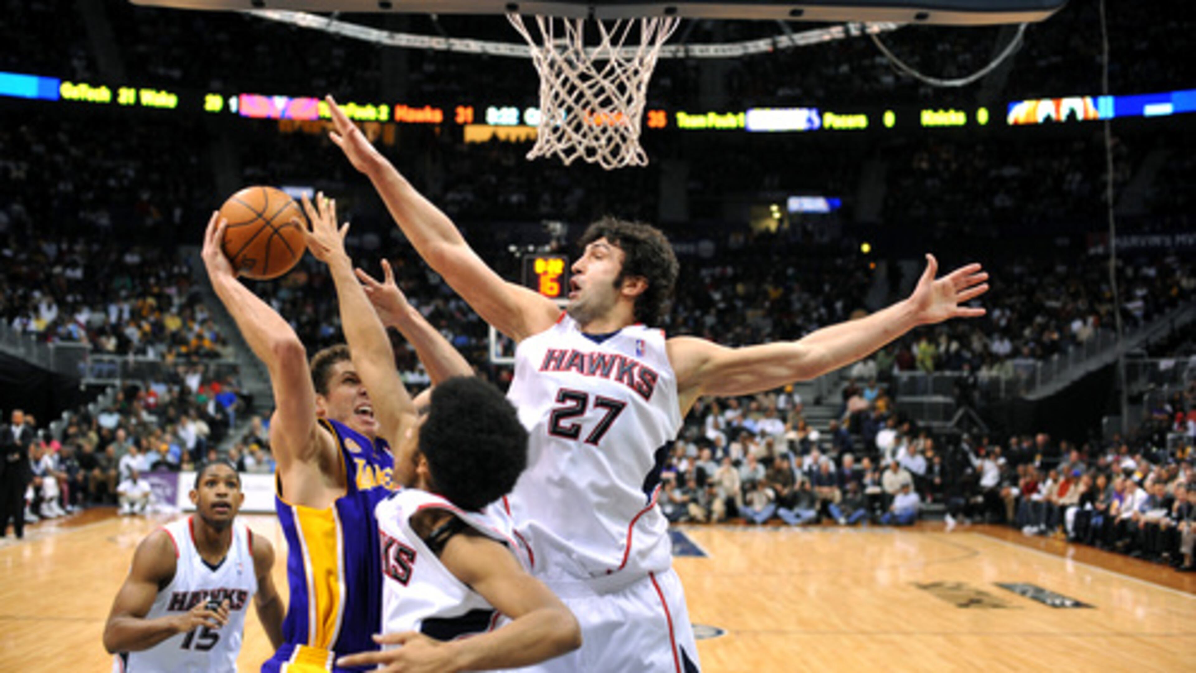In this AJC file photo, Zaza Pachulia of the Hawks goes for a block against Luke Walton of LA. (Rich Addicks/AJC)