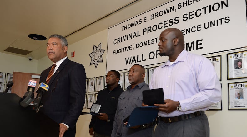 In this 2013 file photo, former DeKalb County Sheriff Thomas Brown (left) speaks at a press conference. )JOHNNY CRAWFORD / AJC)
