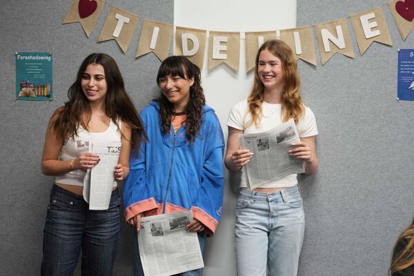 Members of of the Palisades High School newspaper staff, from left to right, Cloé Nourparvar, Gigi Appelbaum, and Kate Swain, hold a copy of the school's publication, which was printed in Philadelphia, Wednesday, May 14, 2025, in Santa Monica, Calif. (AP Photo/Marcio Jose Sanchez)