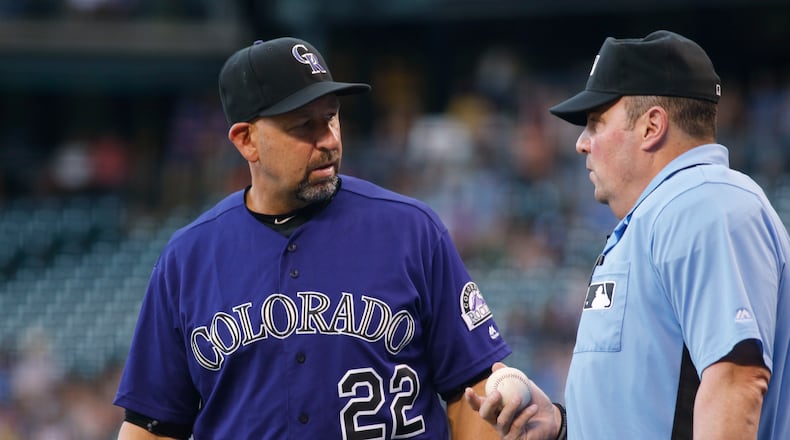 Colorado Rockies manager Walt Weiss, left, confers with home plate umpire Marty Foster after Rockies left fielder Ryan Raburn bobbled and then dropped a fly ball hit by Atlanta Braves' Freddie Freeman that was ruled a triple in the first inning of a baseball game Friday, July 22, 2016, in Denver. (AP Photo/David Zalubowski)