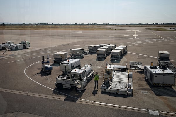 A worker walks on the tarmac at the Saint-Exupery airport, near Lyon, France, as French air traffic controllers launched a two-day strike to demand better working conditions, Friday, July 4, 2025. (AP Photo/Laurent Cipriani)
