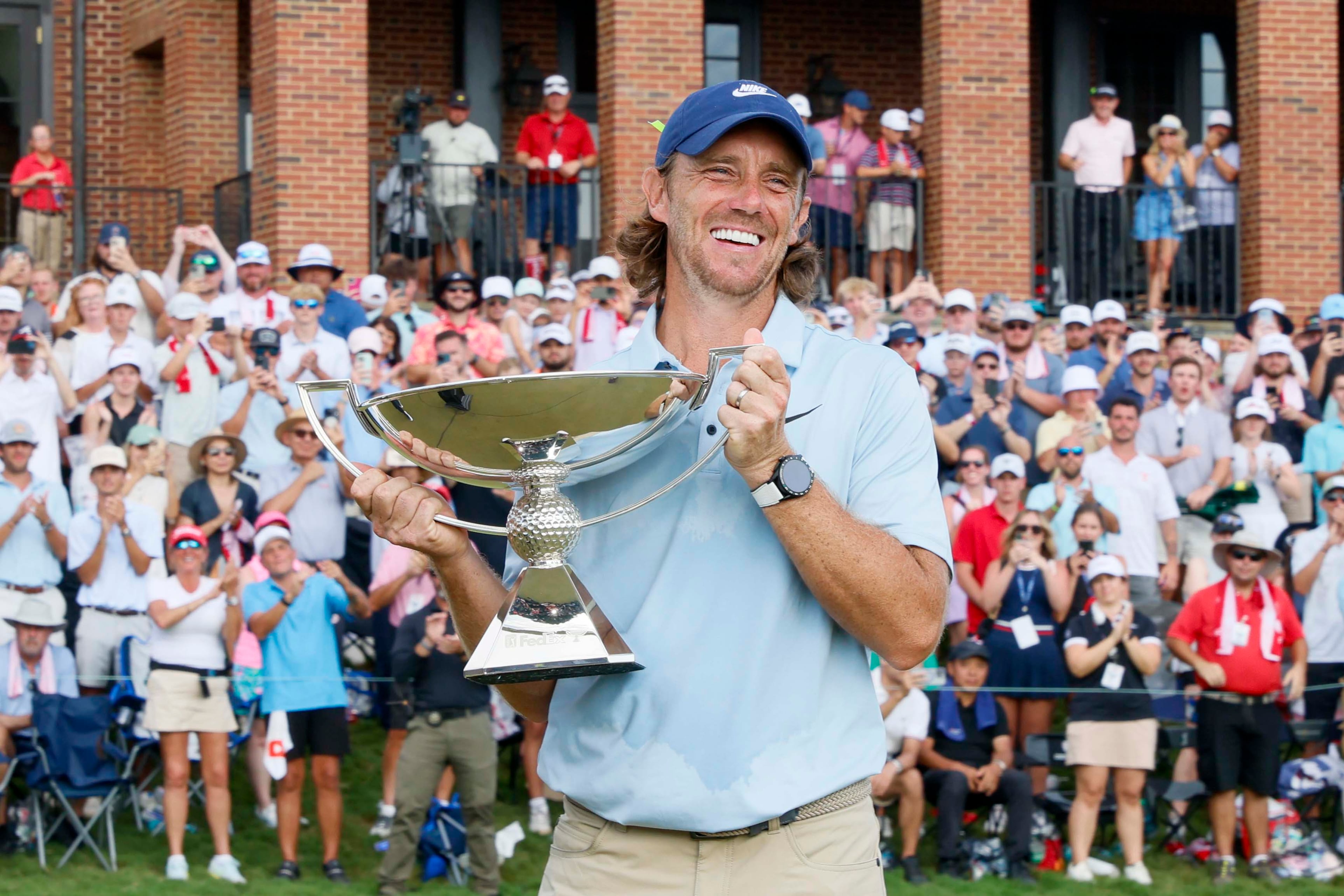 Tommy Fleetwood, of England, smiles as he holds the PGA Tour Championship trophy at East Lake Golf Club, on Sunday, Aug. 24, 2025, in Atlanta. (Miguel Martinez/ AJC)