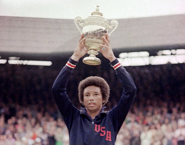 FILE - In this July 5, 1975, file photo, Arthur Ashe holds the men's singles trophy after defeating fellow American Jimmy Conners in the final of the men's singles championship at the All England Lawn Tennis Championship in Wimbledon, London. (AP Photo/File)