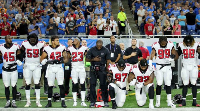 Grady Jarrett and Dontari Poe take a knee during the playing of the national anthem prior to the start of the game against the Detroit Lions at Ford Field on September 24, 2017 in Detroit, Michigan.