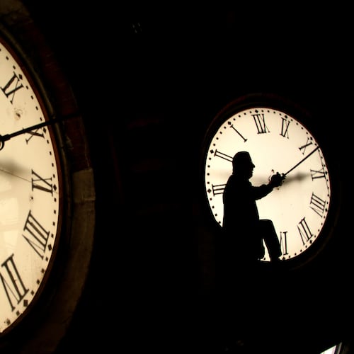 FILE - Custodian Ray Keen inspects a clock face before changing the time on the 100-year-old clock atop the Clay County Courthouse March 8, 2014, in Clay Center, Kan. (AP Photo/Charlie Riedel, File)