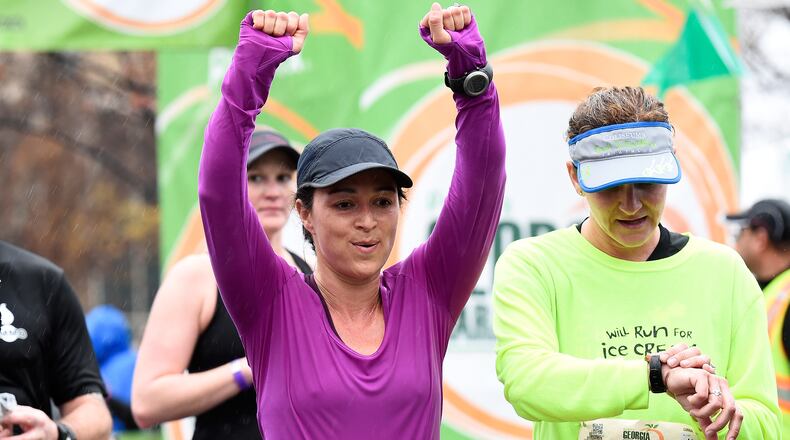 Maria Andrade, of Macon, Ga., (11348) celebrates finishing her Publix Georgia Half Marathon Sunday, March 22, 2015, in Atlanta. David Tulis / AJC Special