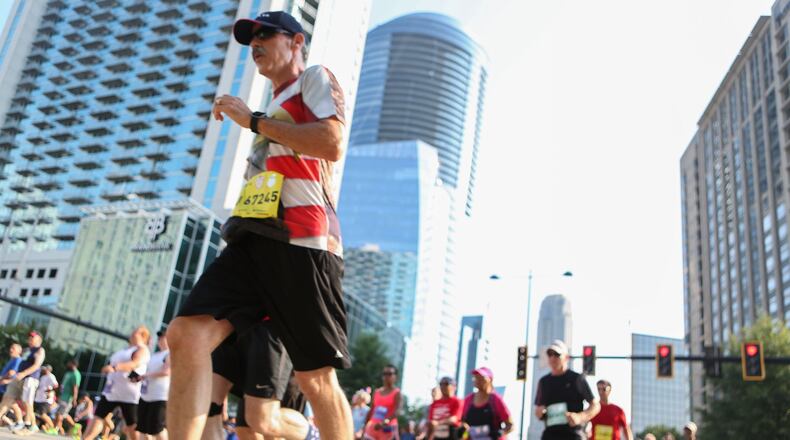 Racers run down Peachtree Road just past the starting line at the 2016 AJC Peachtree Road Race on Monday, July 4. EMILY JENKINS/ EJENKINS@AJC.COM