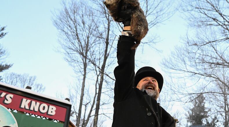 Groundhog Club handler A.J. Dereume holds Punxsutawney Phil, the weather prognosticating groundhog, during the 140th celebration of Groundhog Day on Gobbler's Knob in Punxsutawney, Pa., Monday, Feb. 2, 2026. Phil's handlers said that the groundhog has forecast six more weeks of winter. (AP Photo/Barry Reeger)