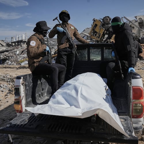 Islamic Jihad and Hamas militants carry a white body bag that is believed to be the remains of a deceased hostage, in the town of Beit Lahiya in northern Gaza Strip, Wednesday, Dec. 3, 2025. (AP Photo/Jehad Alshrafi).