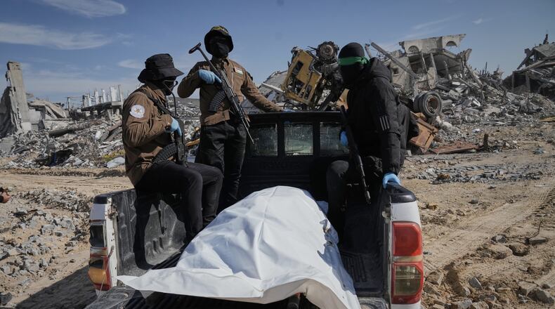 Islamic Jihad and Hamas militants carry a white body bag that is believed to be the remains of a deceased hostage, in the town of Beit Lahiya in northern Gaza Strip, Wednesday, Dec. 3, 2025. (AP Photo/Jehad Alshrafi).