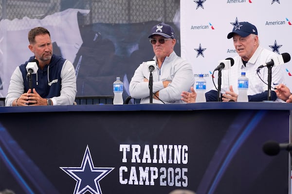 Jerry Jones, right, Dallas Cowboys owner, president, and general manager speaks to reporters as Cowboys head coach Brian Schottenheimer, left, and Stephen Jones, Dallas Cowboys co-owner, executive vice president, CEO, and director of player personnel listen during a news conference to open training camp Monday, July 21, 2025, in Oxnard, Calif. (AP Photo/Mark J. Terrill)