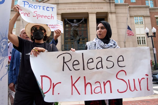 FILE - Mapheze Saleh, right, wife of arrested and detained Georgetown University scholar Badar Khan Suri, holds a sign calling for her husband's release after speaking at a news conference following his hearing at Federal District Court for the Eastern District of Virginia, in Alexandria, Va., Thursday, May 1, 2025. (AP Photo/Jacquelyn Martin, File)