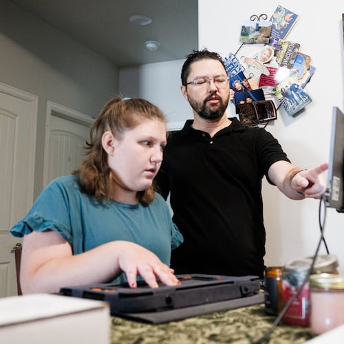 Rob Harris helps his daughter Isabelle Harris with her braille display on Thursday, June 18, 2026, in Grand Junction, Colo. (AP Photo/Jacob Spetzler)