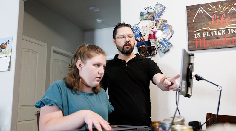 Rob Harris helps his daughter Isabelle Harris with her braille display on Thursday, June 18, 2026, in Grand Junction, Colo. (AP Photo/Jacob Spetzler)