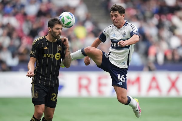 Vancouver Whitecaps' Sebastian Berhalter, right, and Los Angeles FC's Ryan Hollingshead, left, vie for the ball during the second half of an MLS soccer match in Vancouver, British Columbia, Sunday, May 11, 2025. (Darryl Dyck/The Canadian Press via AP)