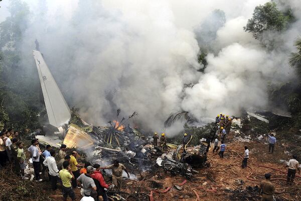 FILE - Civilians look on as Indian firefighters and rescue personnel work on the site of an Air India plane that crashed in Mangalore, in the southern Indian state of Karnataka, Saturday, May 22, 2010. (AP Photo, File)