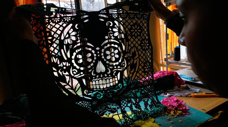 Cande Martinez prepares soccer jerseys, inspired by papel picado and traditional folk art, from the brand Mexclart, in Cuautitlán Izcalli, Mexico, Monday, May 25, 2026. (AP Photo/Marco Ugarte)