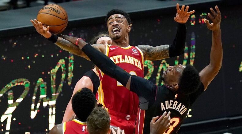 Atlanta Hawks forward John Collins (center top) is fouled by Miami Heat center Bam Adebayo (right) during the second half Sunday, Feb. 28, 2021, in Miami. (Lynne Sladky/AP)