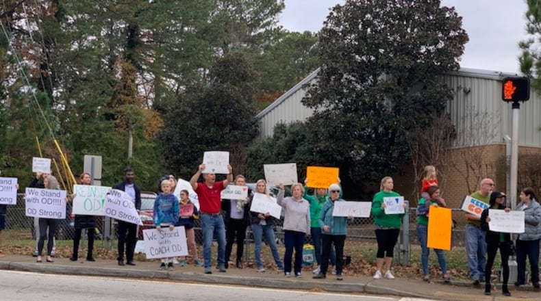 Several dozen parents and community members showed their support for suspended coach James O’Donnell Friday at Henderson Mill Elementary School.
