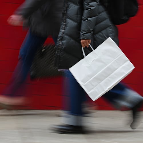 FILE - A person carries a shopping bag in Philadelphia, Dec. 10, 2025. (AP Photo/Matt Rourke, File)