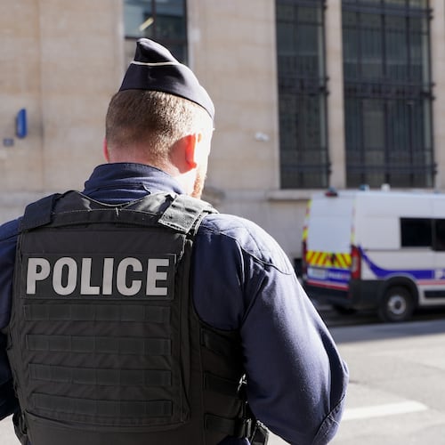 Police stand outside the Bank of America building in Paris, Saturday, March 28, 2026. (AP Photo/Nicolas Garriga)