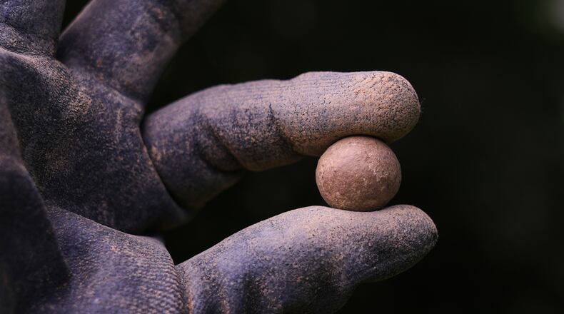 Calla Ruff, an intern from Carleton College, holds a musket ball that was removed from an archaeological dig at the site of the Battle of Bunker Hill, Monday, June 15, 2026, in Boston. (AP Photo/Charles Krupa)