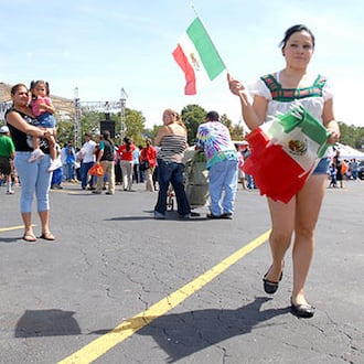 Susana Olague sells Mexican flags during the celebration at Plaza Fiesta. (AJC File)