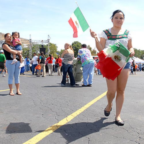 Susana Olague sells Mexican flags during the celebration at Plaza Fiesta. (AJC File)