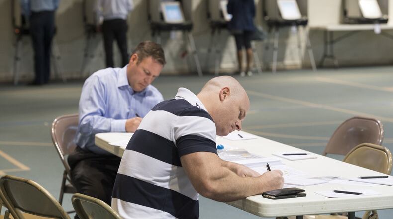 Cobb resident Tony Plummer, center, fills out a voter certificate at Mount Zion United Methodist Church in Marietta, Georgia, on Tuesday, April 18, 2017. Cobb, Fulton and North DeKalb residents cast ballots today for the highly contested 6th Congressional District race. (DAVID BARNES / DAVID.BARNES@AJC.COM)