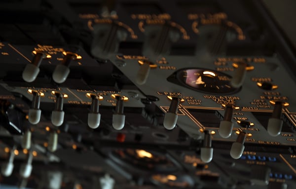 Switches in the cockpit of a United Airlines flight simulator are lit up at the company's training campus in Denver, Friday, May 16, 2025. (AP Photo/Thomas Peipert)