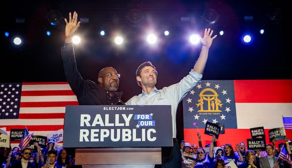 The US Senator Raphael Warnock (left) leads the US Senator Jon Ossoff on stage during a 