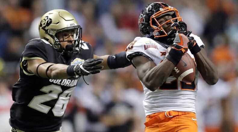 Oklahoma State wide receiver James Washington (28) pulls in a pass in front of Colorado defensive back Isaiah Oliver (26) during the second half of the Alamo Bowl NCAA college football game, Thursday, Dec. 29, 2016, in San Antonio. (AP Photo/Eric Gay)