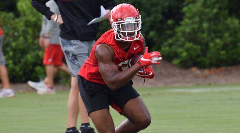 Georgia's Zamir White (3) runs through drills with the other running backs during Friday's practice at Woodruff Practice Fields in Athens.