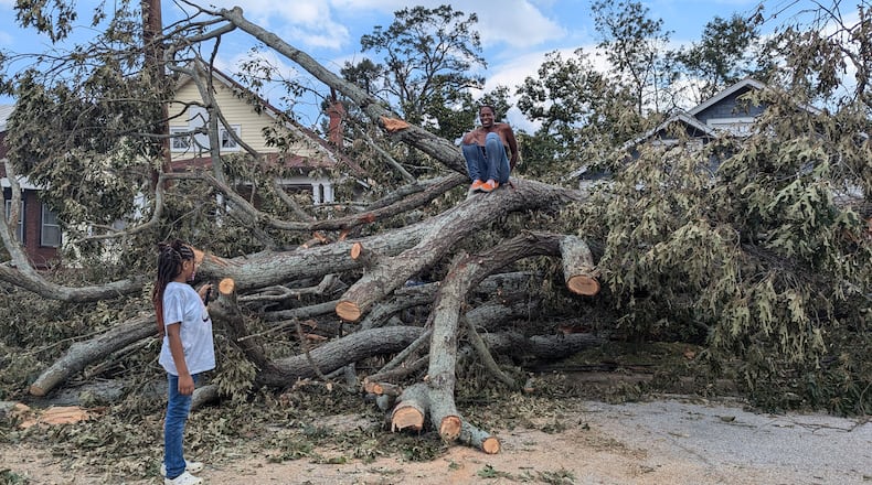 Qena Fabin, an Augusta resident, on top of the oak tree that toppled in her front yard when Hurricane Helene swept through Georgia. (Mirtha Donastorg/The Atlanta Journal-Constitution)