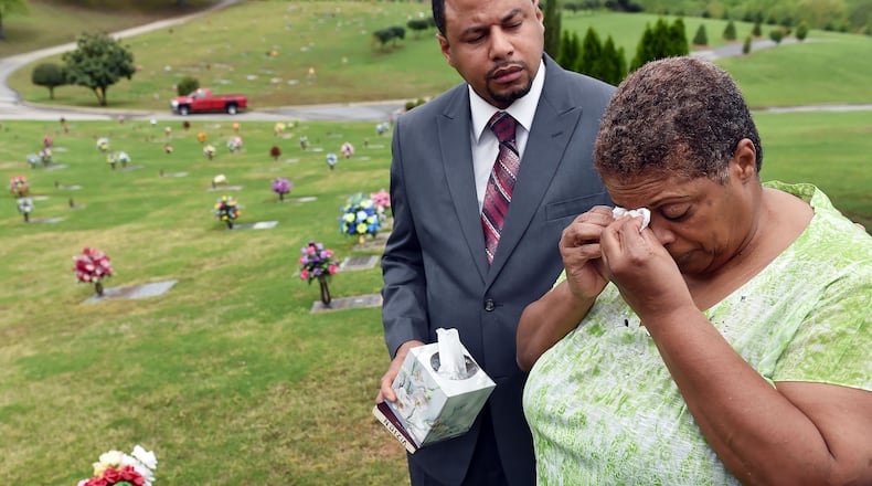Freda Waiters is comforted by Rev. Vizion Jones during a visit to the gravesite of her son, Ariston. Aritston was shot and killed by a Union City police officer in 2011. BRANT SANDERLIN/BSANDERLIN@AJC.COM