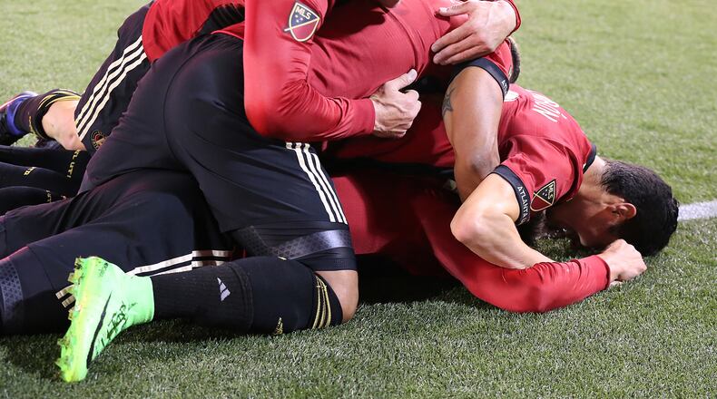 Atlanta United FC players pile on top of Yamil Asad after he scored the team’s first goal for a 1-0 lead against the N.Y. Red Bulls during the first game in franchise history on Sunday, March 5, 2017, in Atlanta. Curtis Compton/ccompton@ajc.com