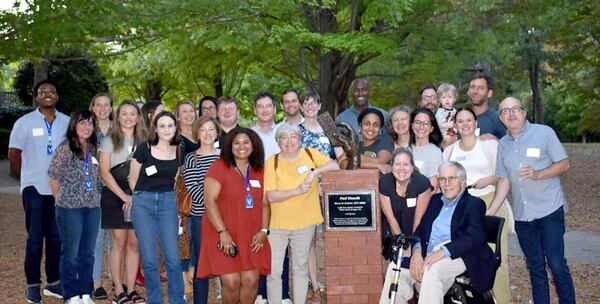 Paul Bianchi gathers with students and staff of the Paideia School next to a statue dedicated to him. The statue's inscription encapsulates his values: "Paideia is not just an accumulation of curriculum and facilities, programs and achievements. The magic sauce is a school culture that regards children optimistically and joyously, as well as celebrates the teachers who create the school every day."  (Courtesy of the Paideia School) 