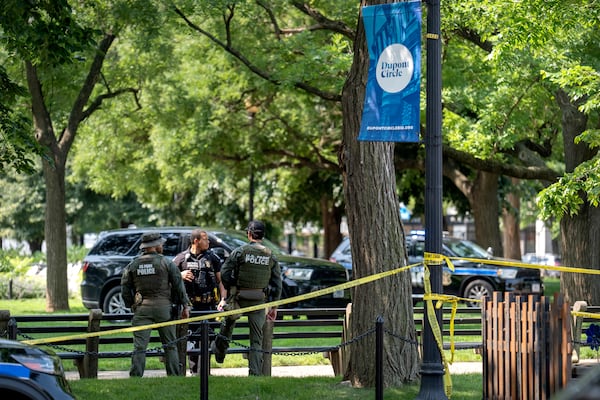 U.S. Park Police stand by as workers put up fencing around Dupont Circle ahead of the World Pride Parade, Friday, June 6, 2025, in Washington. (AP Photo/Mark Schiefelbein)